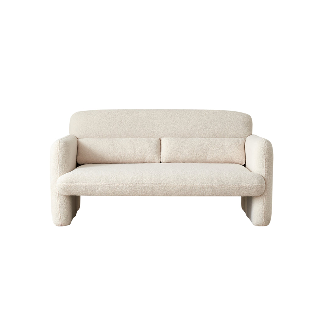 A beige-coloured two-seater sofa with a minimalist design, featuring a low profile and sleek silhouette, made with premium synthetic lambswool upholstery on a concealed steel frame.