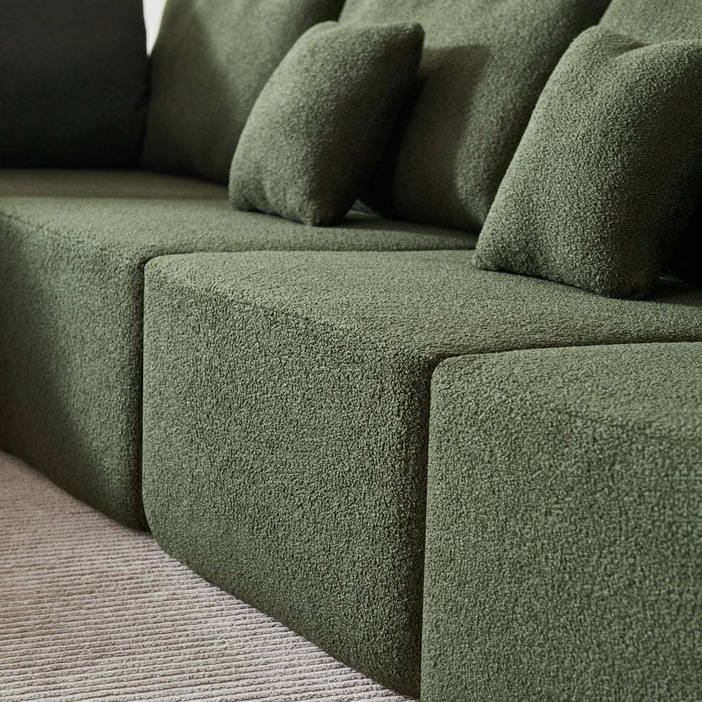 A forest green 5-seater modular sofa with a corner unit and two armrest ends close-up.