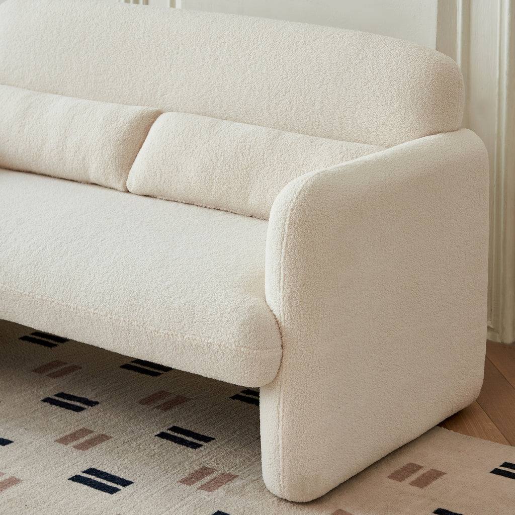 A close-up beige-coloured two-seater sofa with a minimalist design