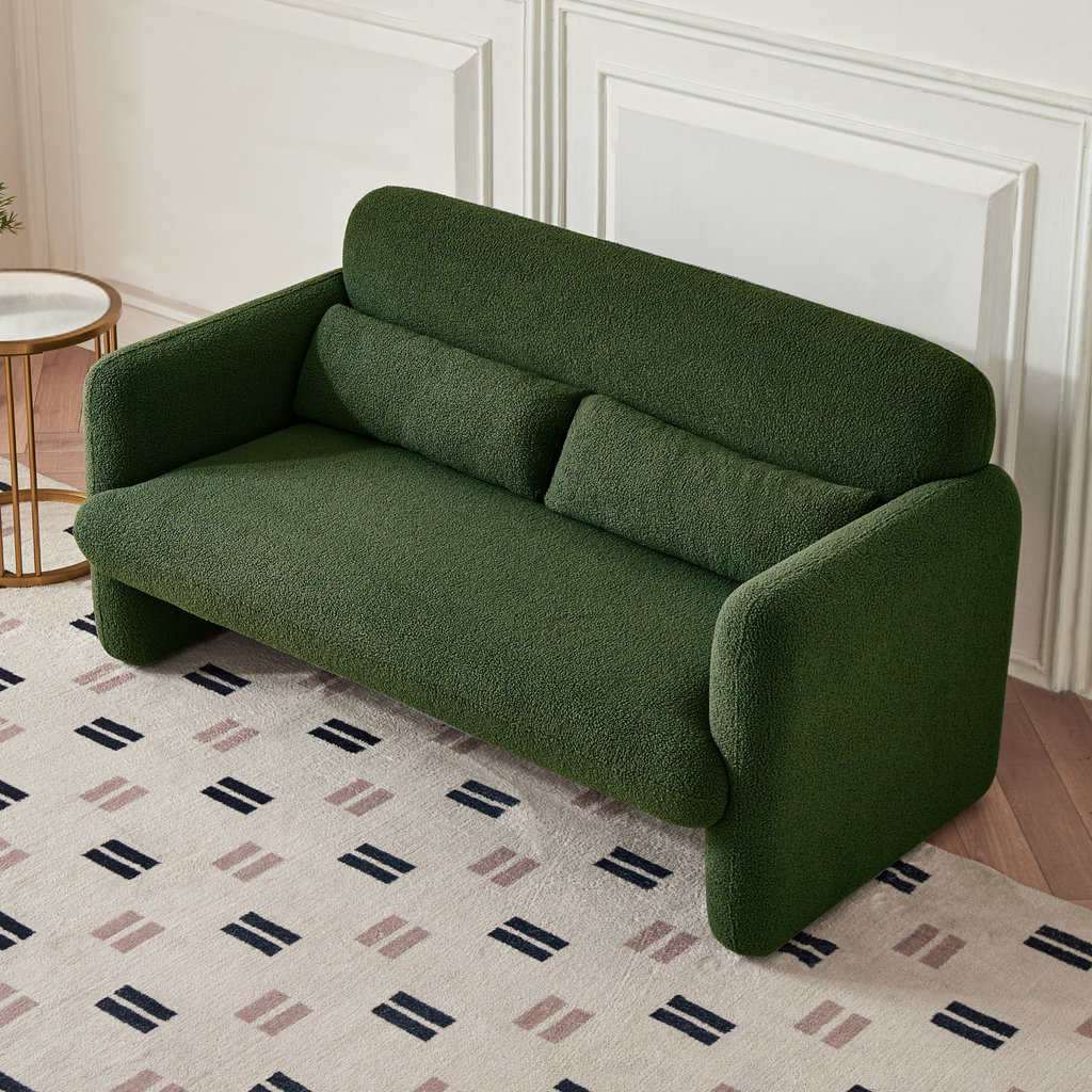 A forest green two-seater sofa with a minimalist design, featuring a low profile and sleek silhouette, made with synthetic lambswool upholstery in a cream room.