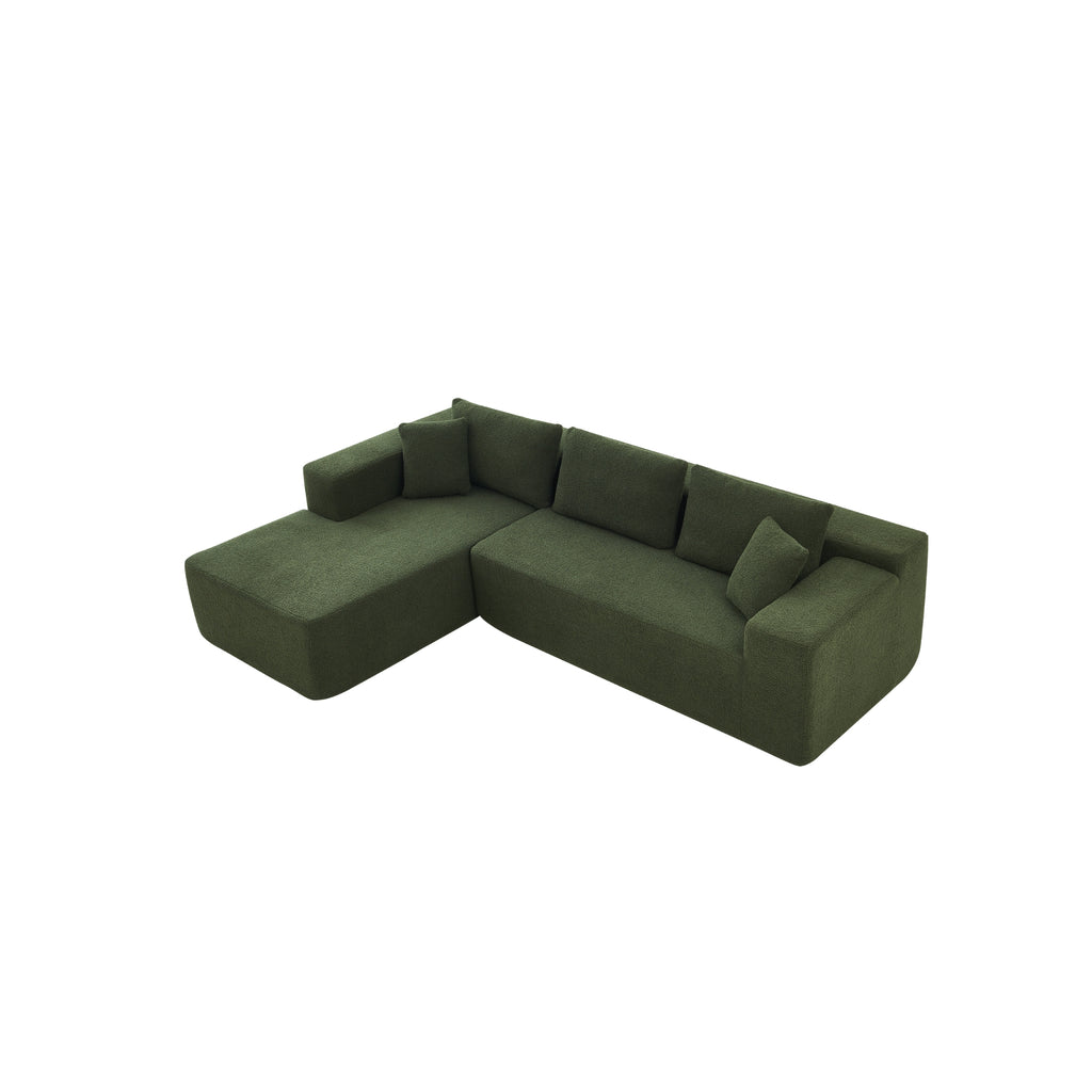 A forest green modular sofa with a left-arm chaise and right-arm seat, upholstered in synthetic lambswool, with a low-profile design.