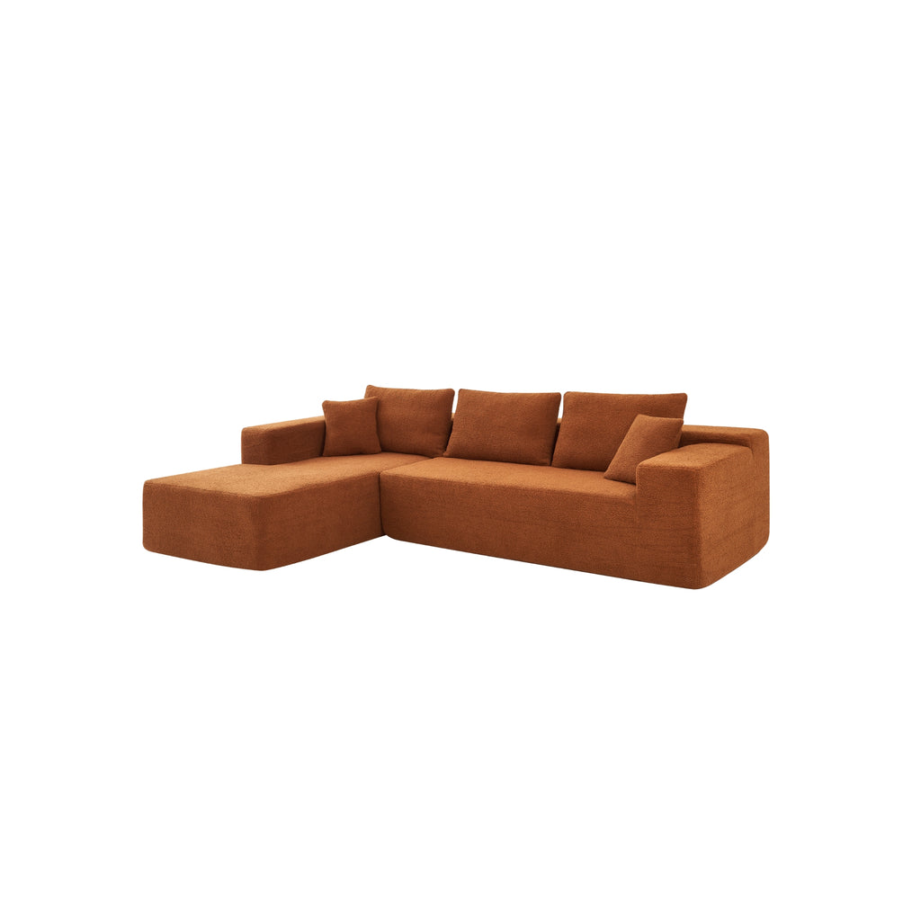 A terracotta orange modular sofa with a left-arm chaise and right-arm seat, upholstered in synthetic lambswool, with a low-profile design.