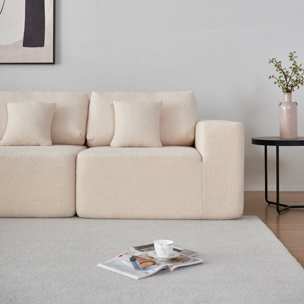 A cream 5-seater modular sofa on a white carpet awith white wall