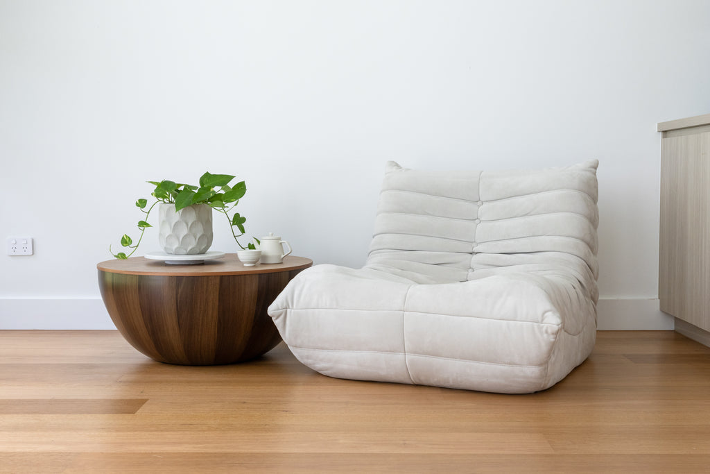 A round, chestnut coffee table with a smooth finish, 