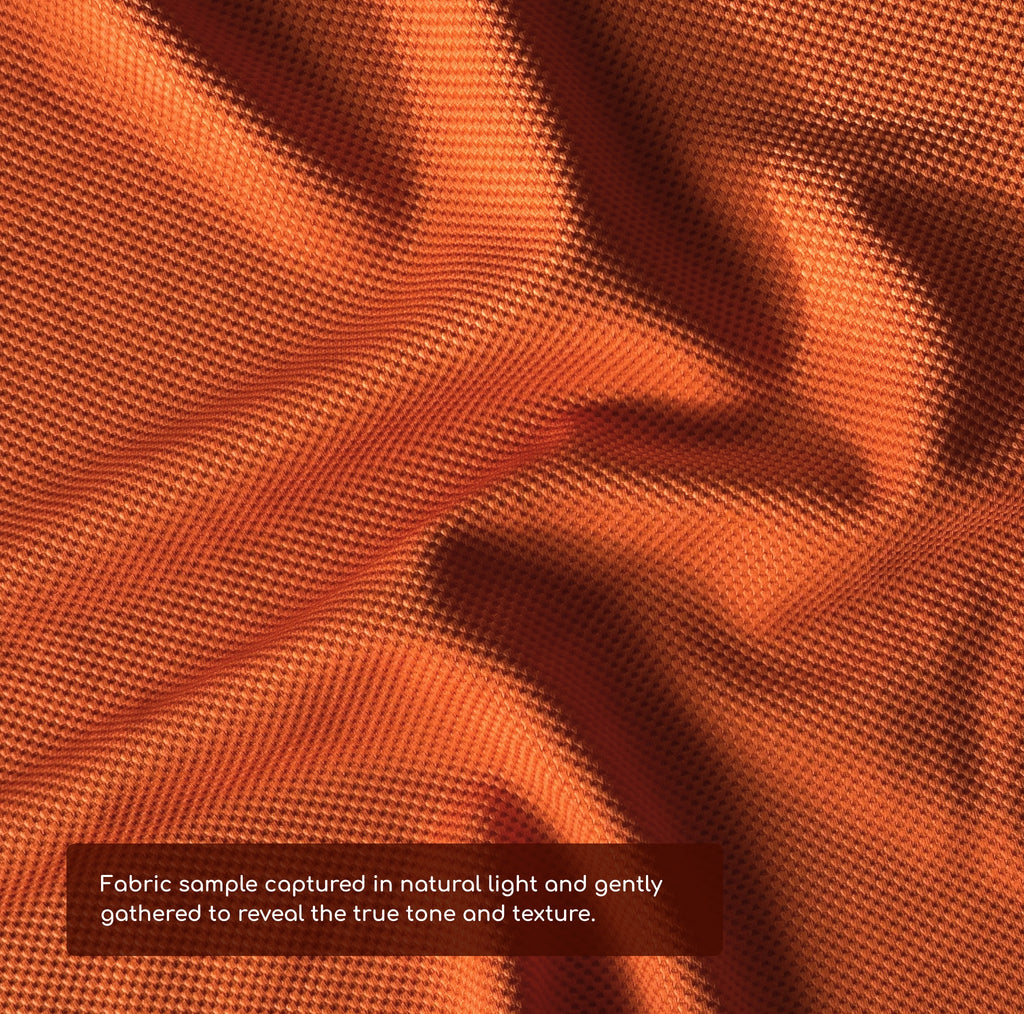 Close-up of tangerine orange fabric with a text overlay about fabric sample details.