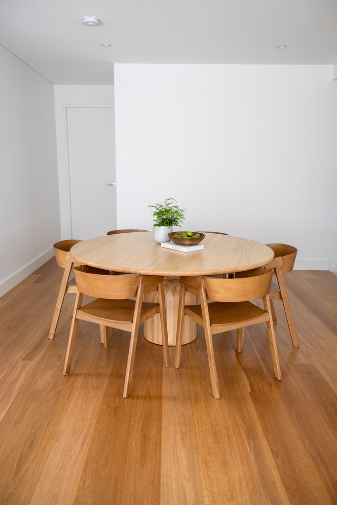 Gather Dining Table  in the middle with white background and a wooden floor