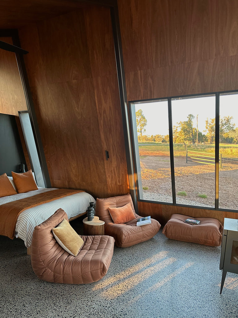 An elegant Junii Fireside sofa in rich ochre, designed with mid-century modern flair in a big room.