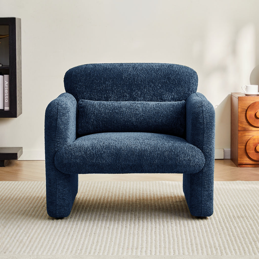 Navy blue armchair in a room with a wooden side table and books.