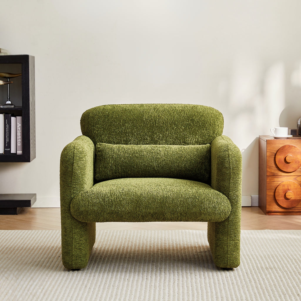 Olive green armchair in a room with a wooden side table and bookshelf.