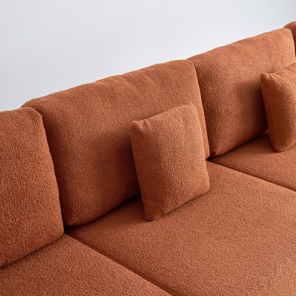 Amber sectional sofa with cushions on a plain background