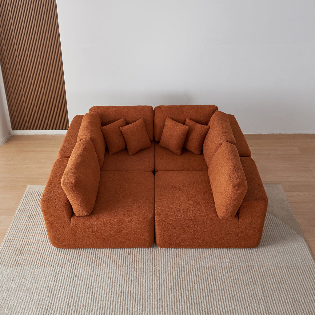 Amber sectional sofa in a minimalistic room with a white wall and wooden floor.