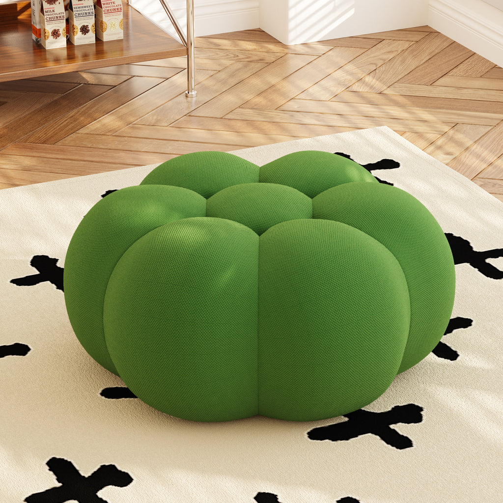 Green pumpkin-shaped cushion on a rug with a wooden floor background