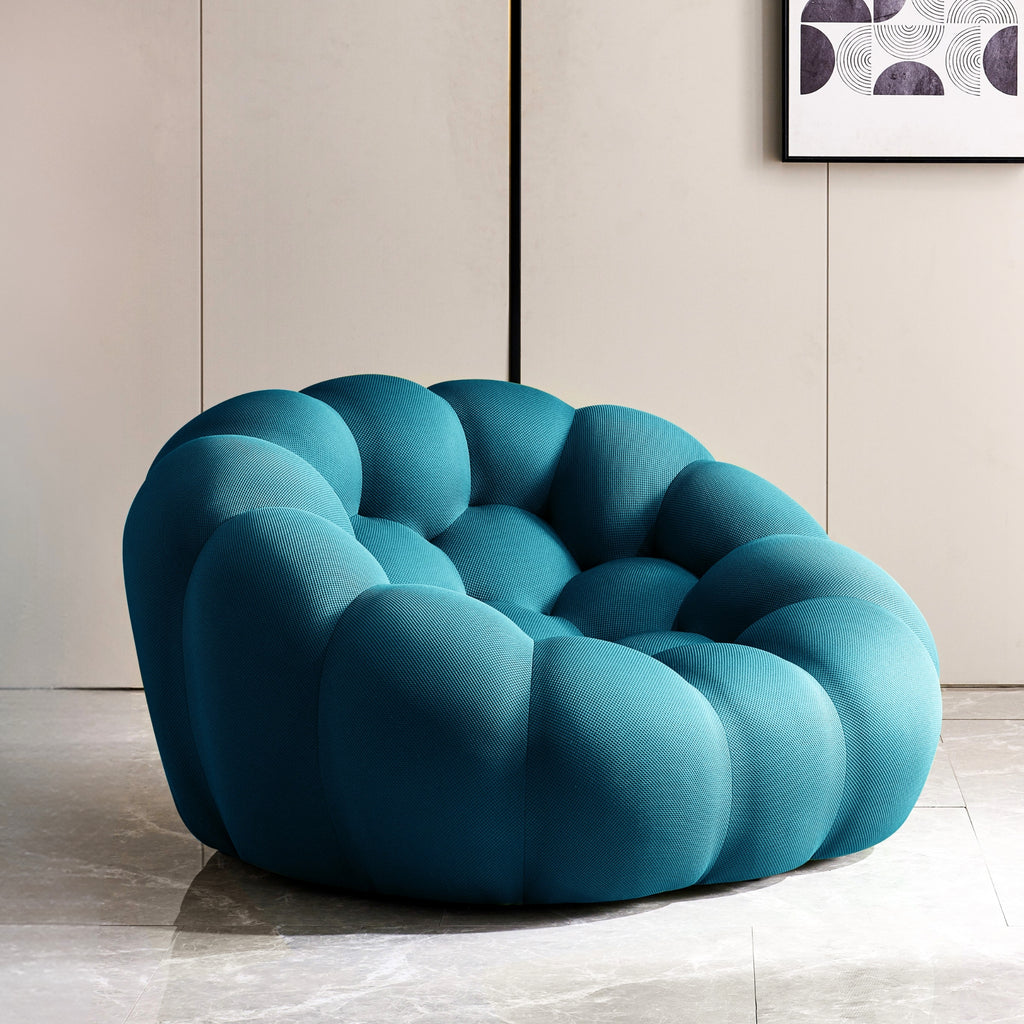 Blue modern bubble sofa in a room with a neutral wall and abstract art.