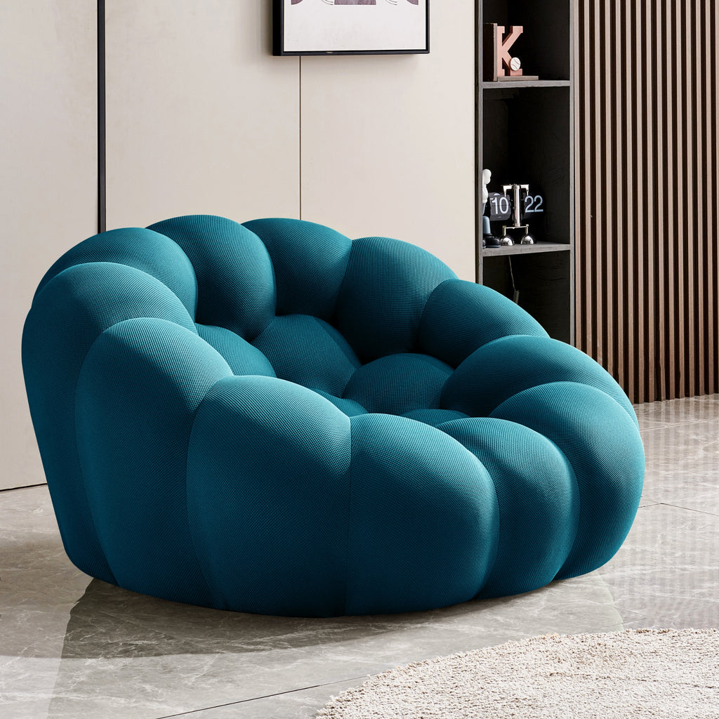 Teal bubble chair in a modern room setting with a shelf in the background.