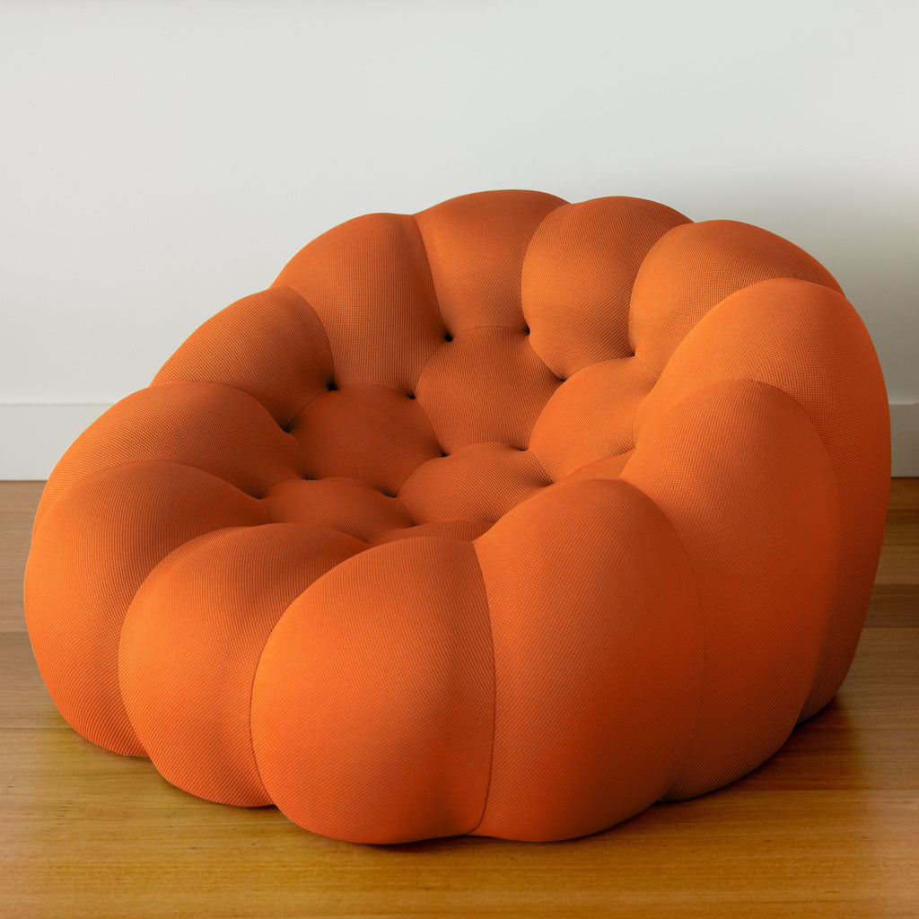 Orange, bubble-style chair on a wooden floor with a white wall background