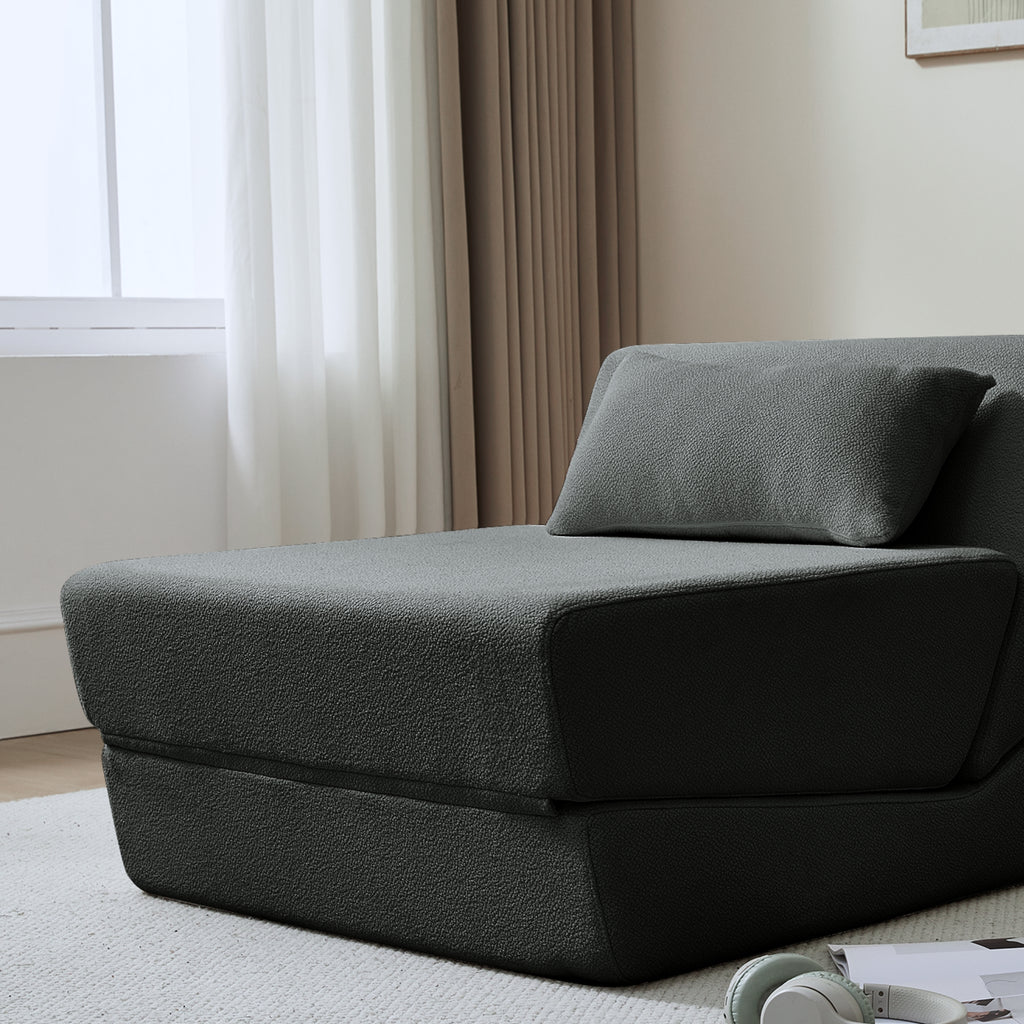 Grey sofa bed in a room with curtains and a window.