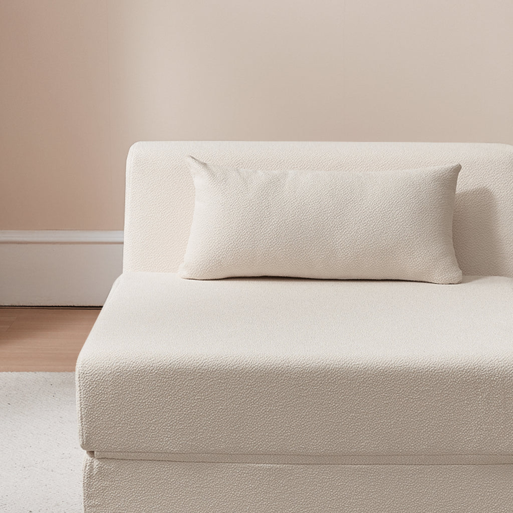 Shell sofa with a textured pillow against a neutral wall.