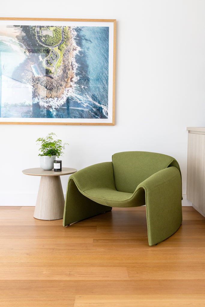 A green Naomi Armchair with a textured boucle fabric, displayed in a spacious room.