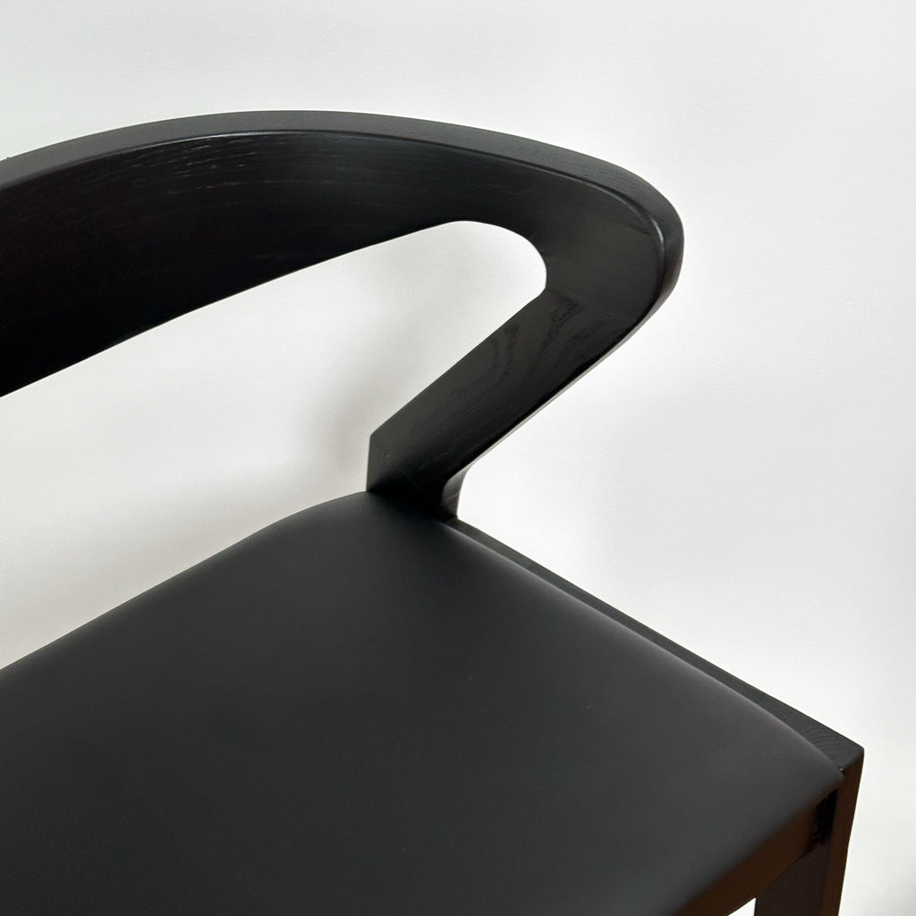 Black bar stool with a modern design on a white background
