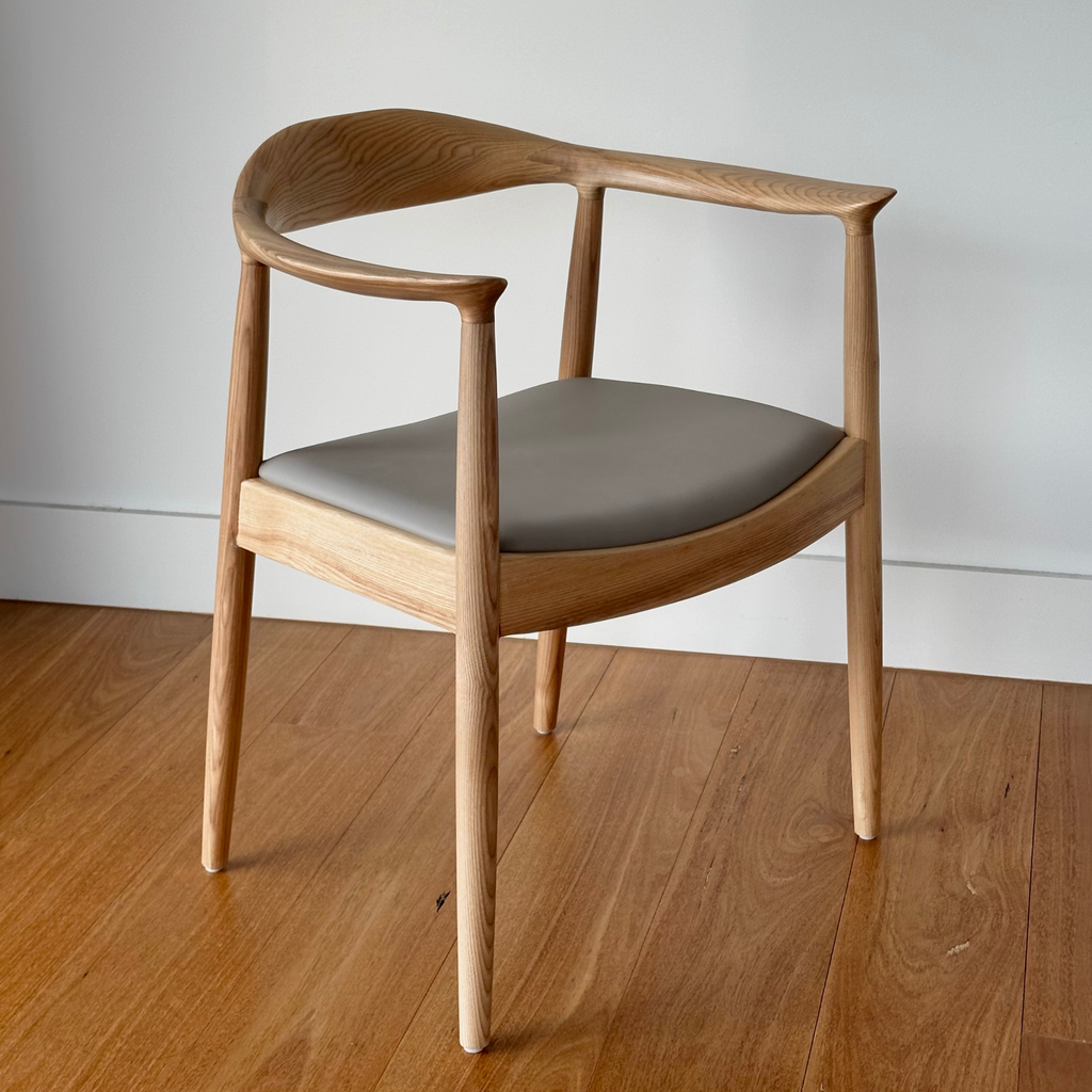 A natural timber dining chair with a pebble grey seat cushion