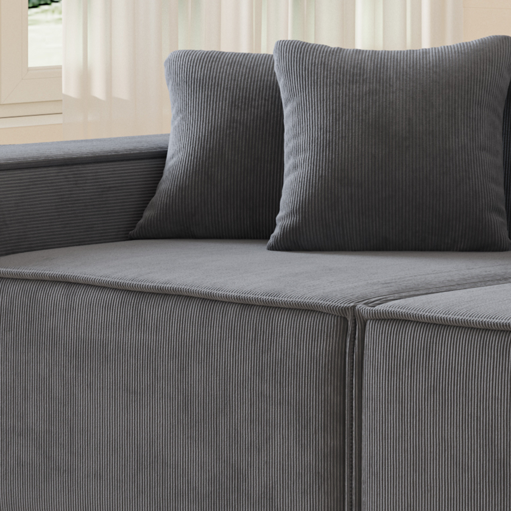 A slate grey two-seater corduroy sofa, featuring a modern, low-profile design with plush cushions